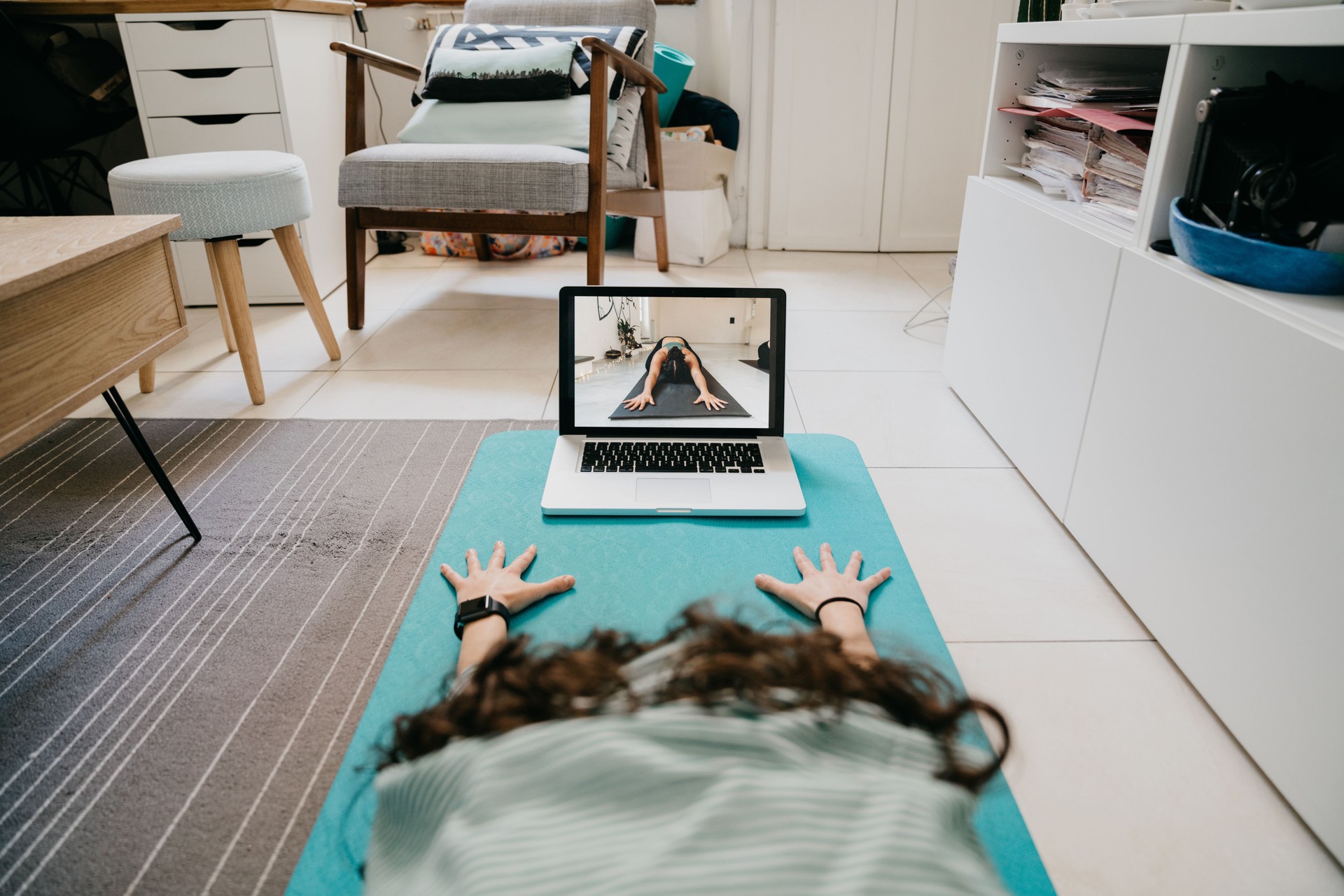 Mujer joven practicando yoga en casa